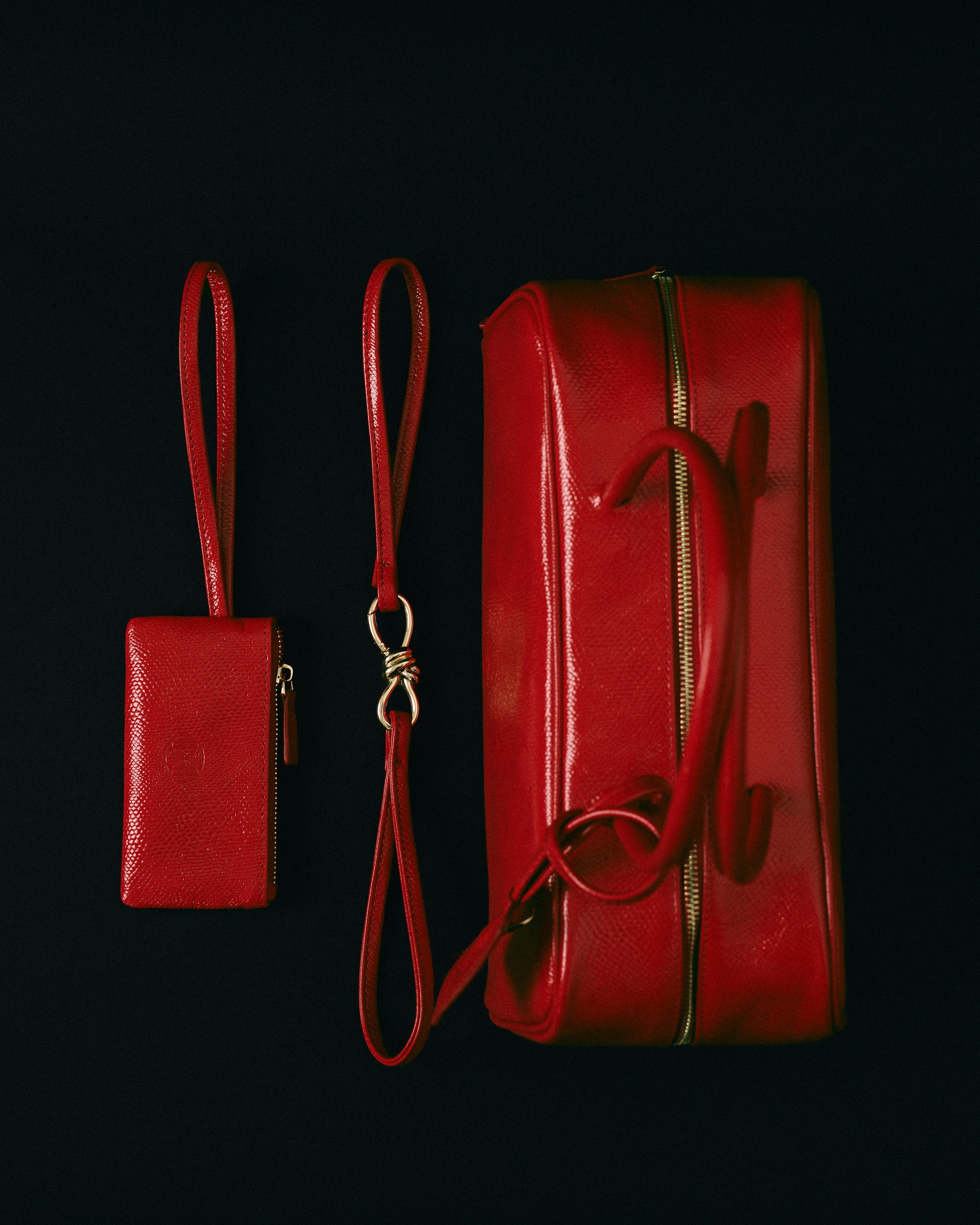 Red leather handbag with matching pouch on a black background